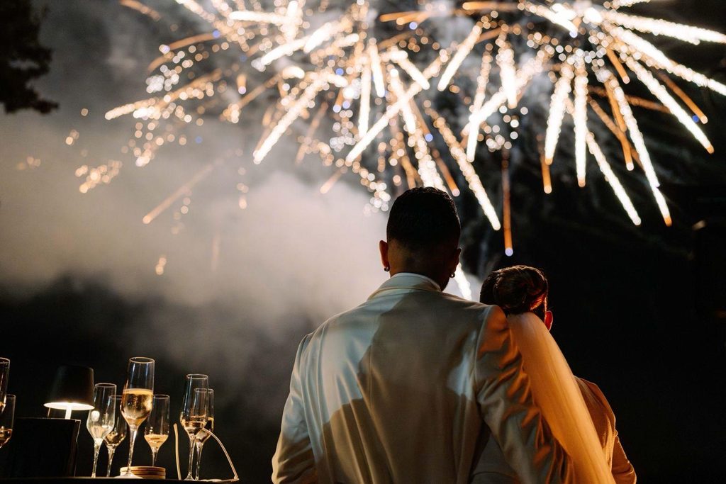 Hochzeitspaar schaut auf Feuerwerk
